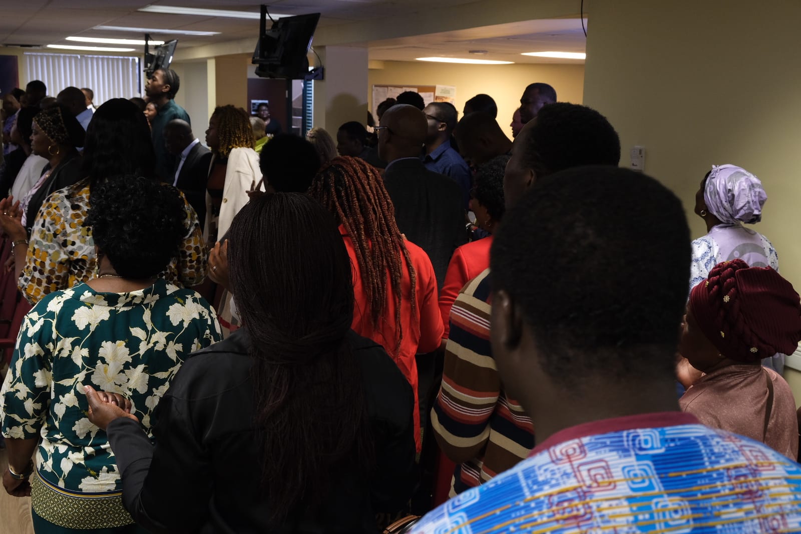 Une salle comble se tient debout pour la louange